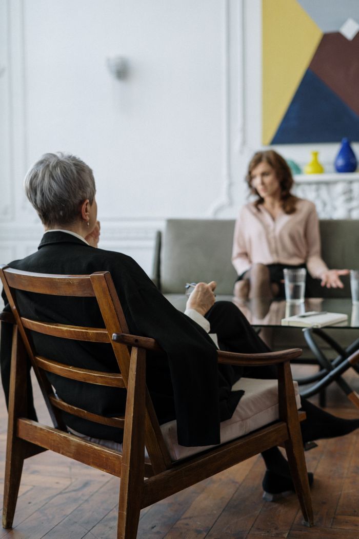 services-06 A therapist and patient engaged in a counseling session in a modern office setting.